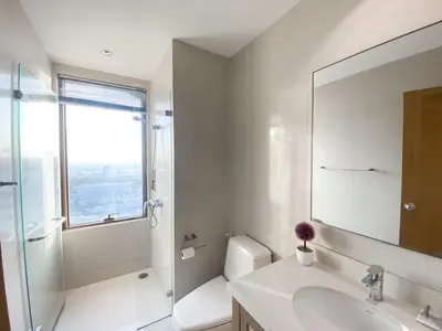 a white bathroom with a sink and a mirror at The Grand Penthouse 2BR Ultra Fast WiFi Sukhumvit in Bangkok