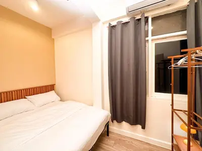 a small bedroom with a bed and a window at Bangkok Neighborhood Hostel in Bangkok