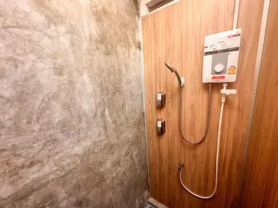 a shower in a bathroom with a wooden wall at Bangkok Neighborhood Hostel in Bangkok
