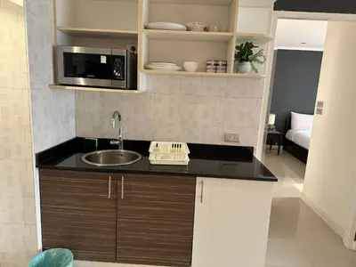 a kitchen with a sink and a microwave at Rent Omni Tower Apartments Nana Bangkok - Prime Sukhumvit location in Bangkok