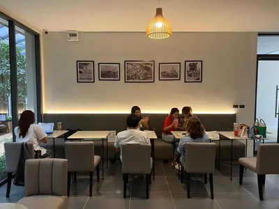 a group of people sitting at tables in a restaurant at 35 Bow Hotel in Ban Bang Bamru