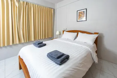 a bedroom with a bed with two towels on it at Tom Guest House ทอมส์ เกสต์เฮ้าส์ in Thung Maha Mek