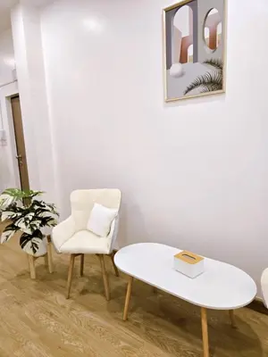 a living room with a white table and a chair at Vevey Mansion in Bangkok