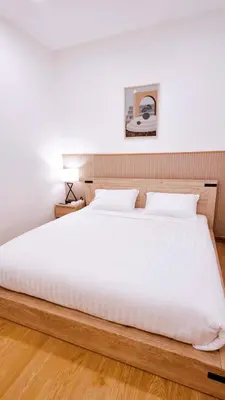 a bedroom with a large bed with white sheets at Vevey Mansion in Bangkok
