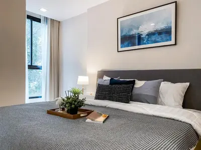 a bedroom with a large bed with a table on it at Tropical Apartment- Ultra Fast WiFi- BTS Thong Lor in Bangkok
