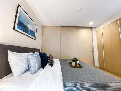 a bedroom with a large bed with a picture on the wall at Tropical Apartment- Ultra Fast WiFi- BTS Thong Lor in Bangkok
