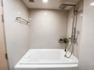 a white bathroom with a tub and a shower at Tropical Apartment- Ultra Fast WiFi- BTS Thong Lor in Bangkok