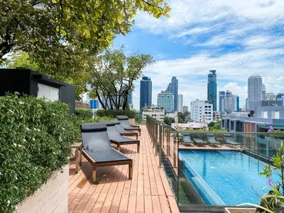 a row of chairs on a balcony with a city skyline at Tropical Apartment- Ultra Fast WiFi- BTS Thong Lor in Bangkok