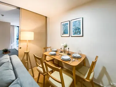 a living room with a table and a couch at Tropical Apartment- Ultra Fast WiFi- BTS Thong Lor in Bangkok