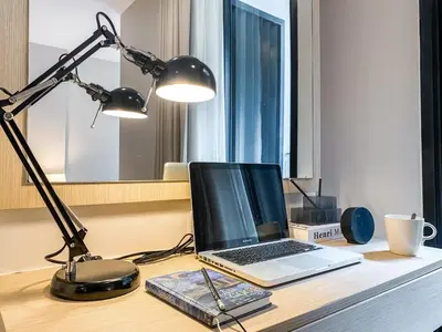 a laptop computer sitting on a desk with a lamp at Tropical Apartment- Ultra Fast WiFi- BTS Thong Lor in Bangkok