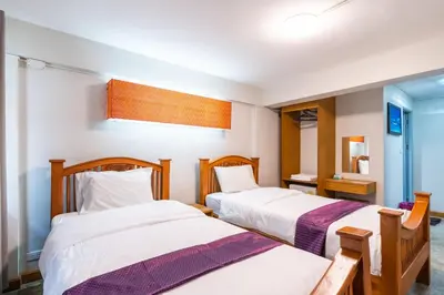 a bedroom with two beds and a mirror at XX GO INN Khaosan Road BKK - Grand Palace in Bangkok