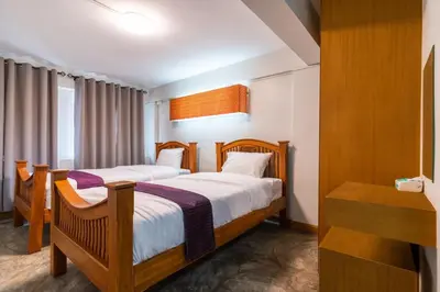a hotel room with two beds and a desk at XX GO INN Khaosan Road BKK - Grand Palace in Bangkok