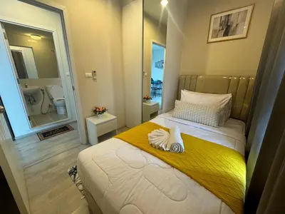 a bedroom with a bed with a yellow blanket and a mirror at Minimal 2 BR next to IKEA, Central Westgate Bangyai in Ban Bang Krabu