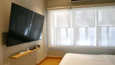 a bedroom with a flat screen tv and a window at The Staytion Hotel at Sukhumvit in Amphoe Phra Khanong