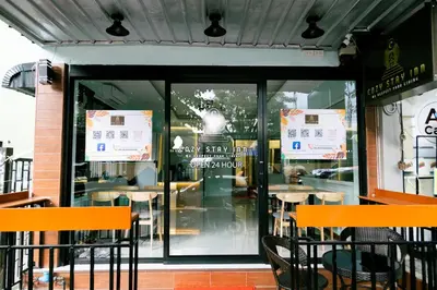 a restaurant with orange chairs in front of a window at Cozy Stay Inn in Bang Kapi
