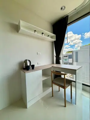 a kitchen with a table and a chair and a window at 5 mins to Ari - Sutthisan in Bang Su