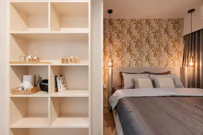 a bedroom with a bed with white shelves at Sweet stay in Bangkok