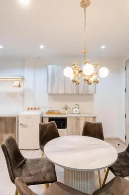 a kitchen with a table and chairs and a chandelier at Sweet stay in Bangkok