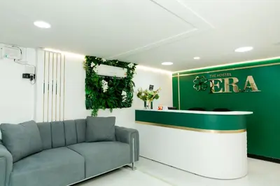 a living room with a couch and a green wall at The Hostel Era in Bangkok