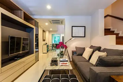 a living room with a couch and a tv at Sukhumvit 16 Townhouses, InHome Luxury Residences in Bangkok