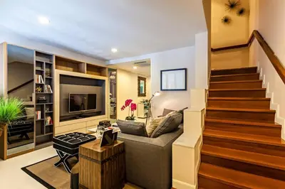 a living room with a staircase and a couch at Sukhumvit 16 Townhouses, InHome Luxury Residences in Bangkok