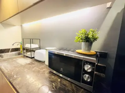 a kitchen with a black microwave on a counter at 5BRHouse City centre Silom 3min to BTS Saint Louis in Bangkok