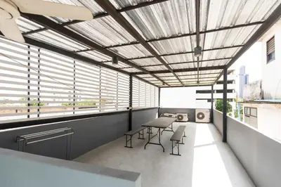 a room with a table and chairs and windows at Forfam at Ekkamai in Khlong Toei