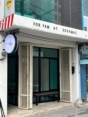 a sign on a building with a bench in front at Forfam at Ekkamai in Khlong Toei