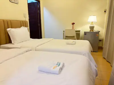 a hotel room with three beds with towels on them at Apamet Hotel Sukhumvit 55 in Khlong Toei