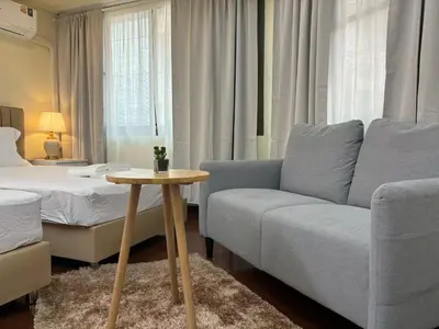 a living room with a couch and a bed at Apamet Hotel Sukhumvit 55 in Khlong Toei