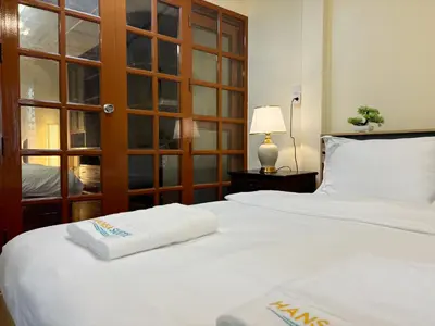 a bedroom with two white towels on a bed at Apamet Hotel Sukhumvit 55 in Khlong Toei