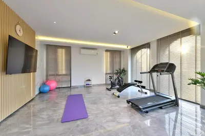 a gym with exercise equipment and a flat screen tv at V32 Hotel in Ban Zong Katiam