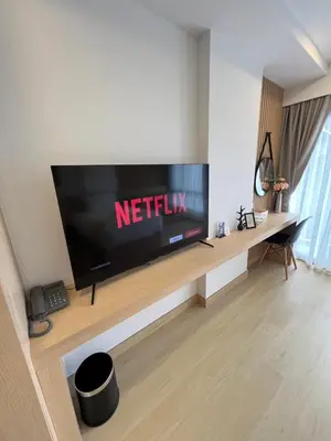 a living room with a flat screen tv on a wall at V32 Hotel in Ban Zong Katiam