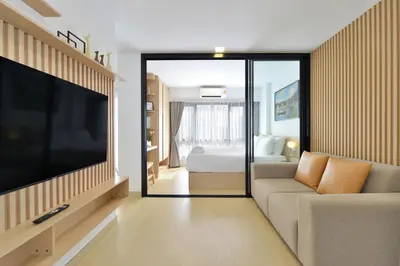a living room with a large television and a couch at V32 Hotel in Ban Zong Katiam