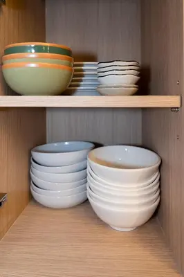 a cabinet filled with plates and bowls on shelves at Pillow BKK Bliss townhome 5BR,7TL near BTS&MRT QSCC in Khlong Toei