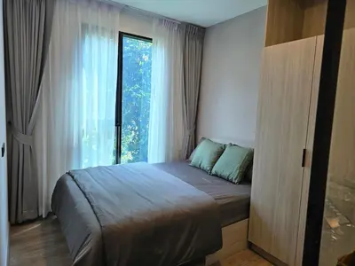 a bedroom with a bed with a large window at The Chapter One Lifestyle Condo in Bang Khen