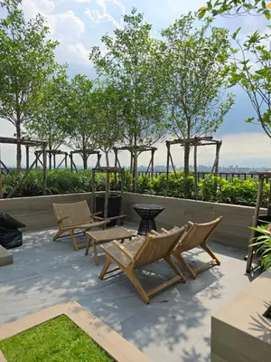 a patio with a table and chairs and trees at The Chapter One Lifestyle Condo in Bang Khen