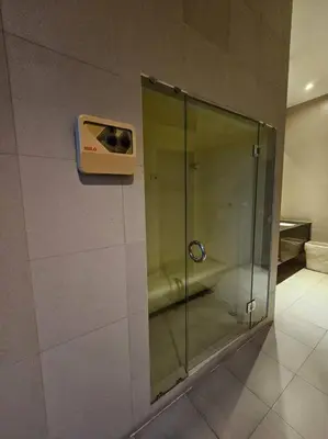 a shower with a glass door in a bathroom at 1BR at ThongLor BTS overlooking city with Workspace in Bangkok