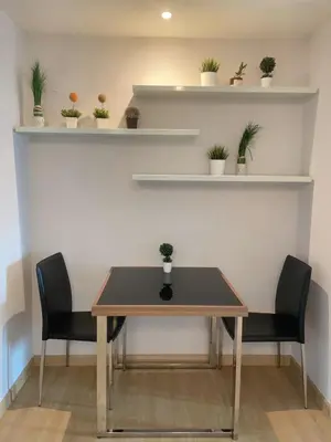 a table and two chairs with plants on shelves at Luxury Condominium in Bangkok