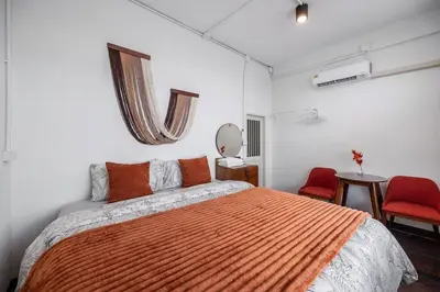 a bedroom with a bed and two red chairs at Sorrento Bangkok Old Town MRT Samyot in Bangkok