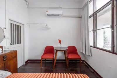 a room with two red chairs and a table and window at Sorrento Bangkok Old Town MRT Samyot in Bangkok