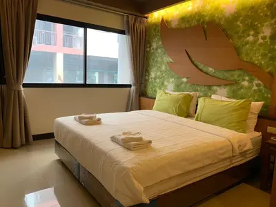 a bedroom with a large bed with two towels on it at Le Ram Hotel No window in Bangkok