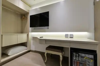 a small kitchen with a sink and a tv at Syama Mansion Phromphong in Bangkok