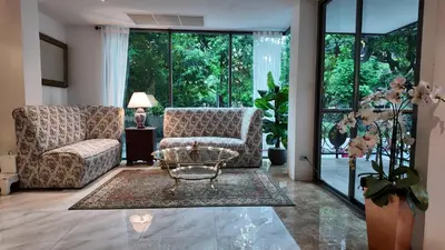 a living room with a couch and a table at Syama Mansion Phromphong in Bangkok