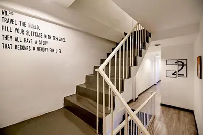 a staircase with a quote on the wall at The rabbit's hole hostel in Bangkok