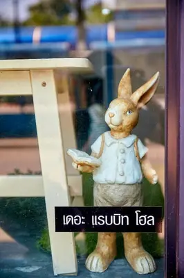 a figurine of a rabbit standing next to a table at The rabbit's hole hostel in Bangkok