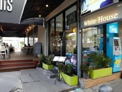 a white house restaurant with plants in front of it at White House Asoke Sukhumvit 18 in Bangkok