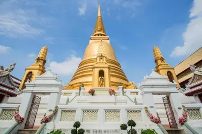 a large golden pagoda with a blue sky in the background at Thamrongin Hotel in Bangkok