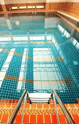 a swimming pool with a chair in the middle at AC Sport Village in Bangkok
