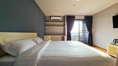 a bedroom with a large bed and a window at We Resident in Ban Bang Toei (1)